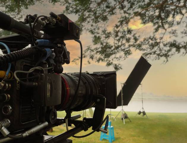 Movie Camera. Behind the video camera that for recording film commercial or movie at outdoor location. 35 mm film styled 4K digital camera and tripod dolly crane for video production. film industry.